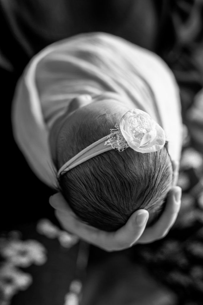 Black and White Mama Hand holding newborn head