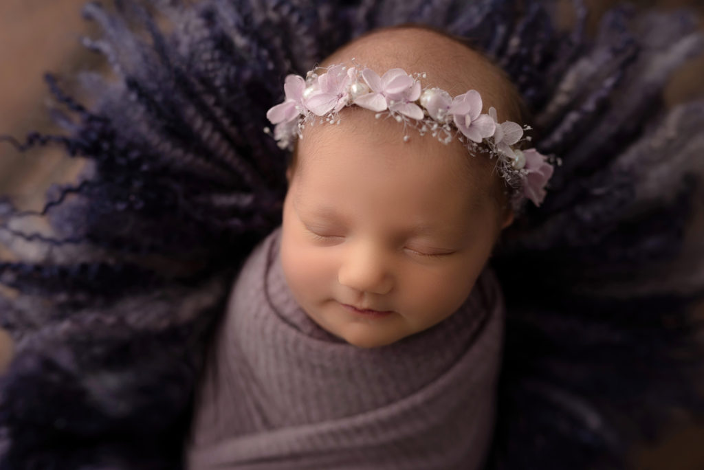 Baby in wool fuzz all purple flower halo swaddled