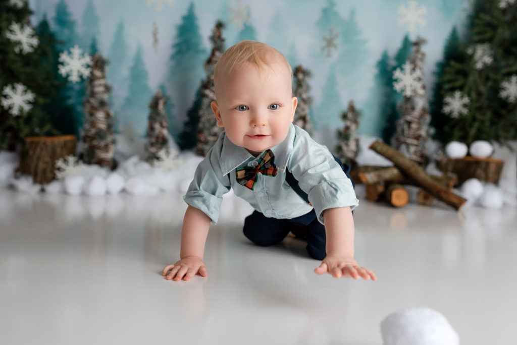 Little boy chasing snowing on decorated winter setup