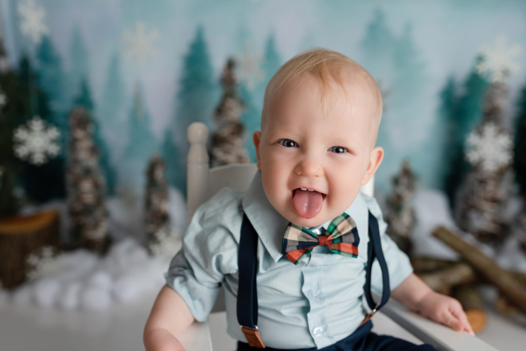Silly baby boy portrait sticking tongue out in bowtie