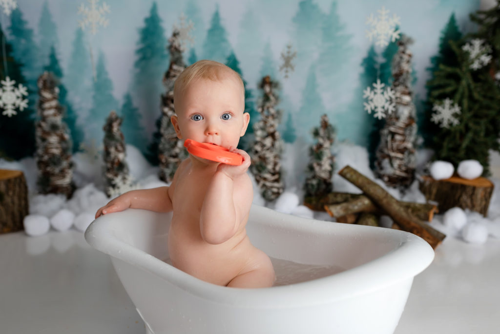 naked baby boy in bathtub in snow wonderland cake smash studio setup