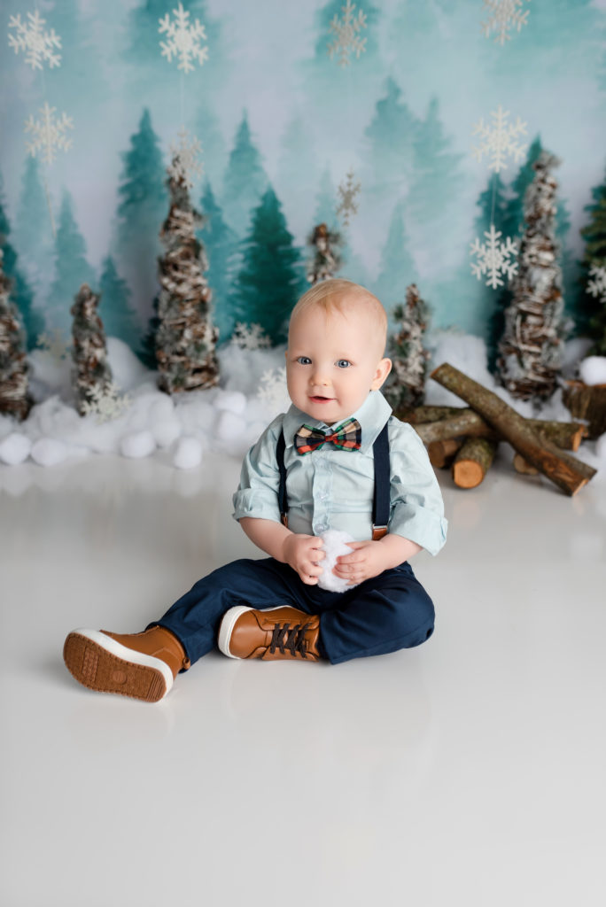 Blonde boy in bowtie and suspenders photo snow and trees