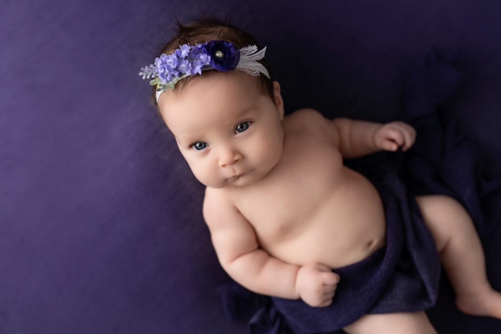 Baby girl purple headband flowers posed for photo shoot