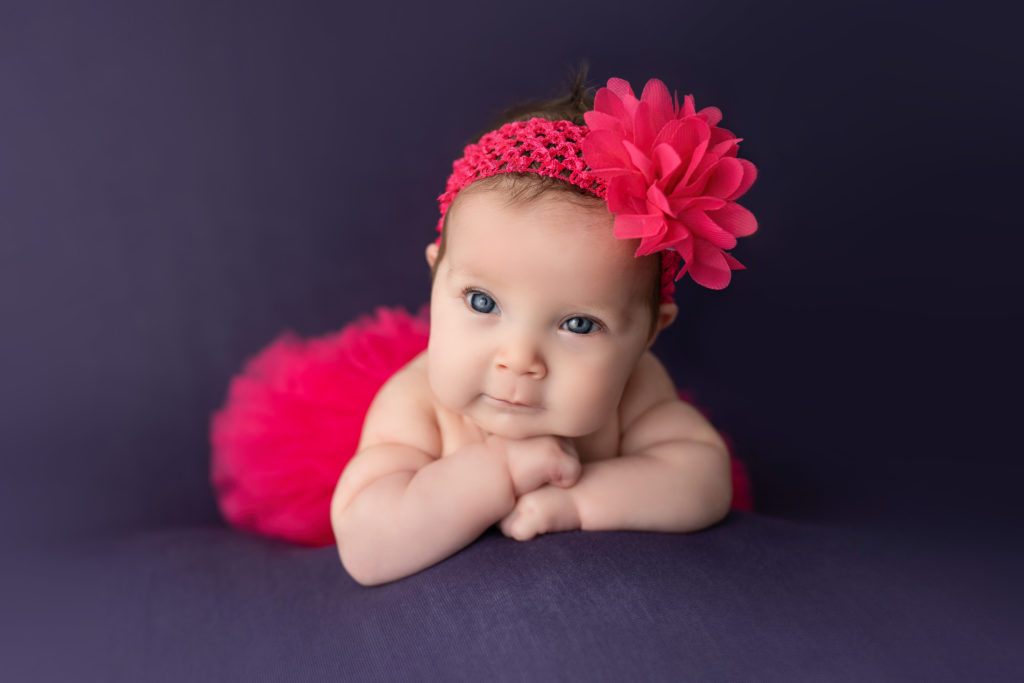 Pink tutu on newborn girl chin on hands pose studio photography