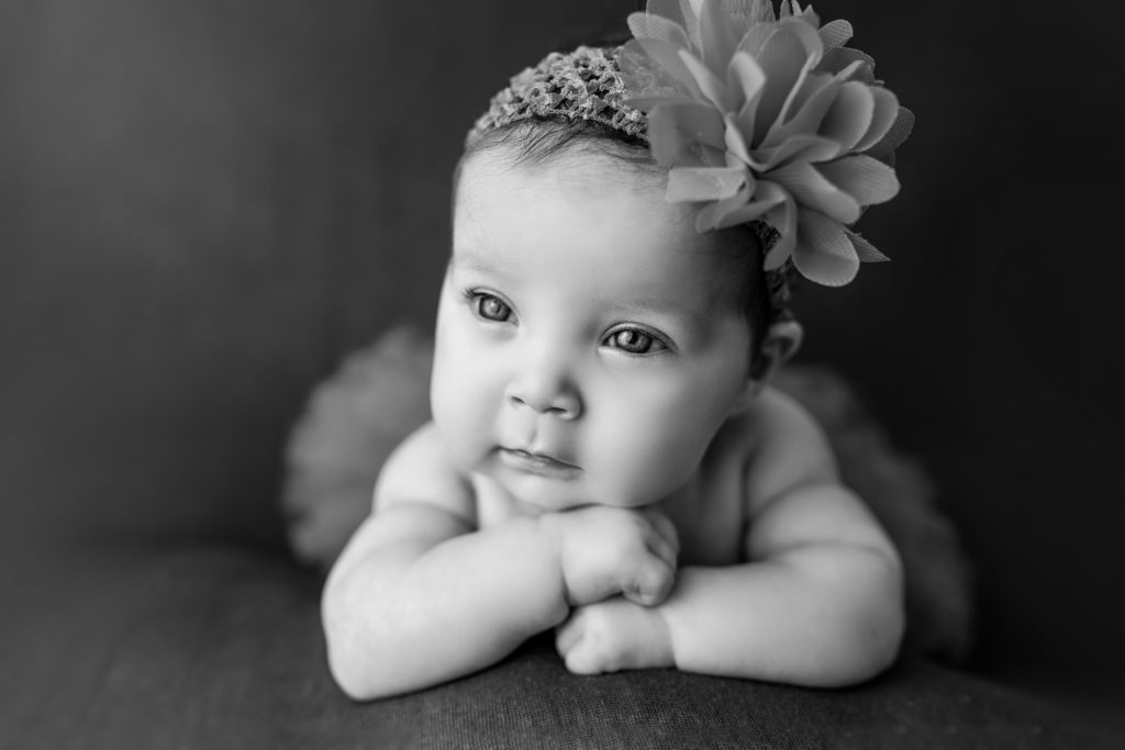 Baby gaze chin on hands black and white posed newborn photo