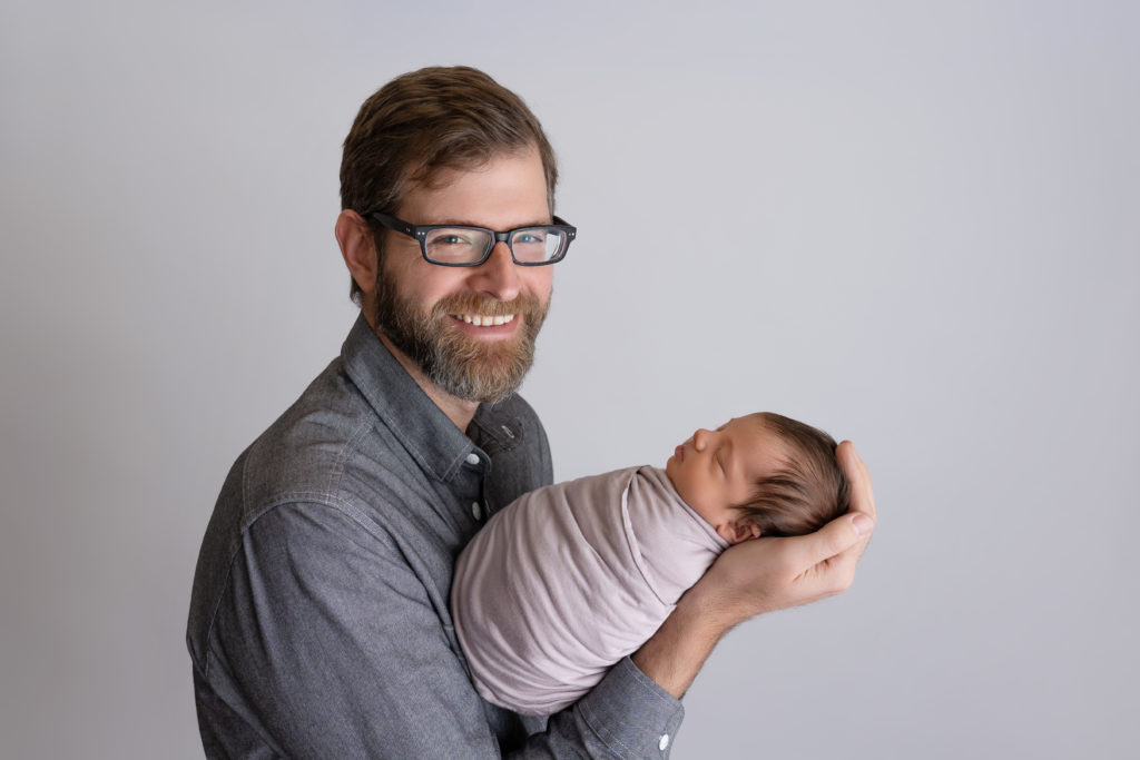 Dad holding baby girl smiling at camera indian trail NC studio