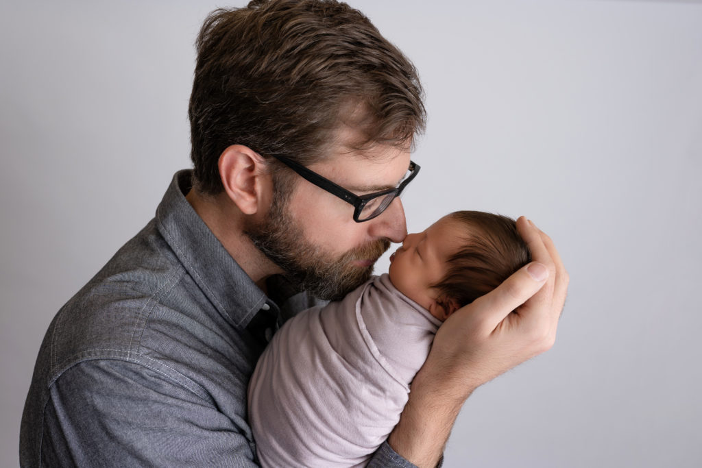 nose to nose dad and newborn baby girl close up studio photo