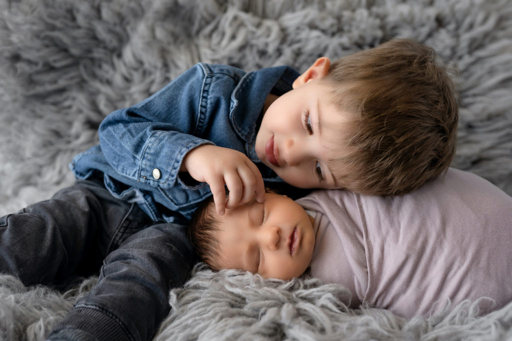Big brother loving on new sister during newborn photo session