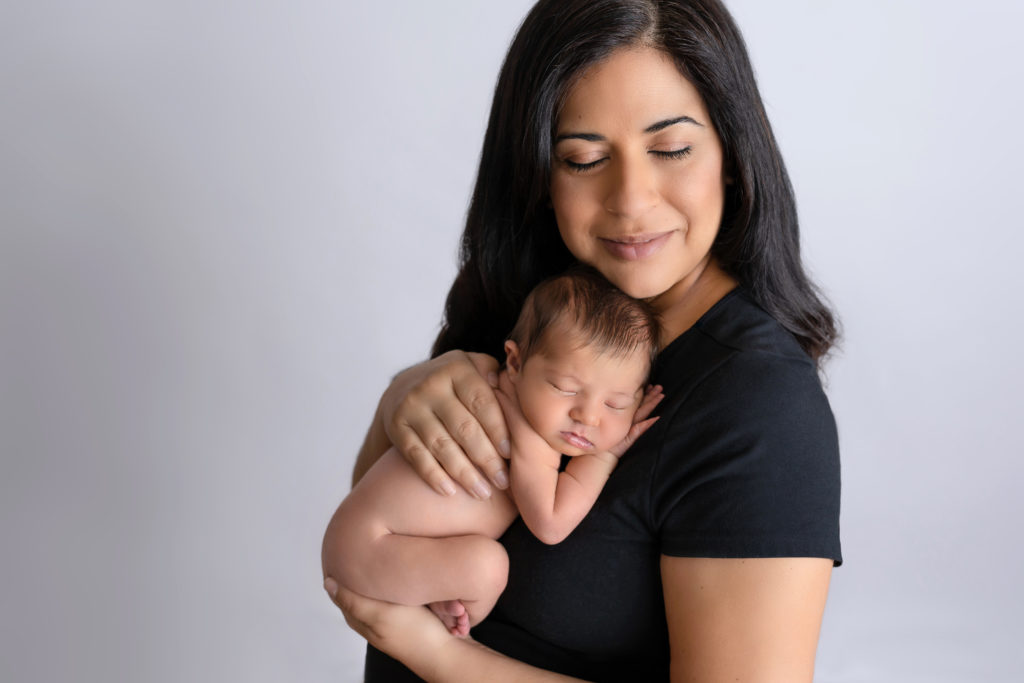 Closed eye mom with sleeping naked baby on heart posed studio portrait charlotte nc