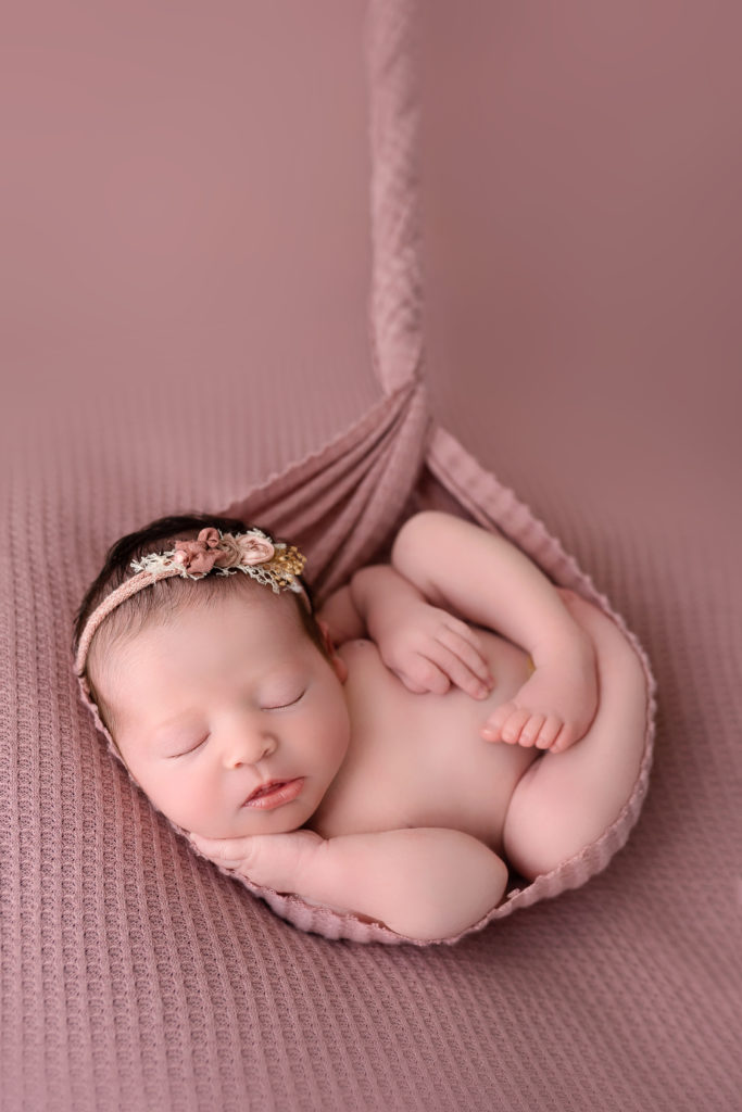 newborn baby cozy in pink blanket