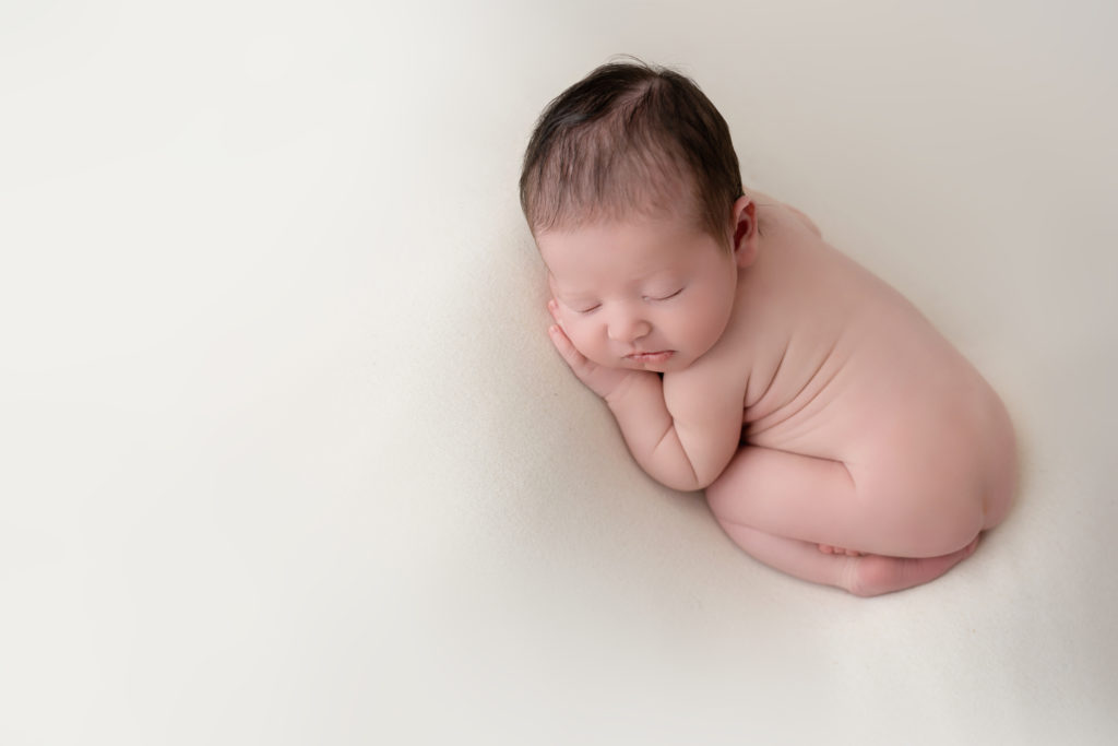 sleeping baby posed in white pillow in studio Indian Trail