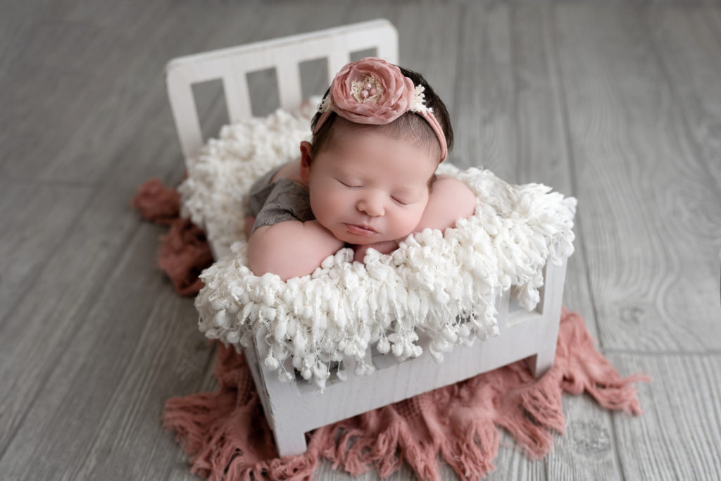 newborn baby naps on bed for studio photography session