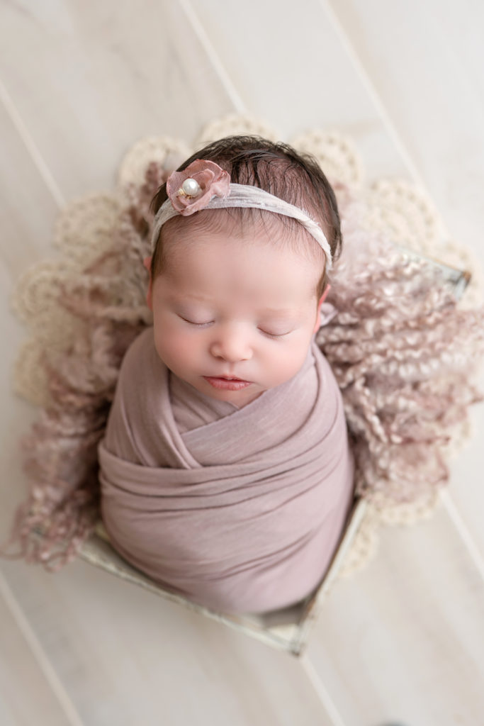 Charlotte newborn photography session wrapped posed baby