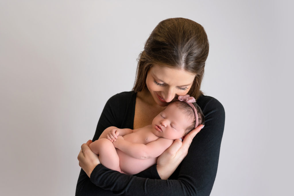 new mom loving baby daughter during newborn session in Matthews