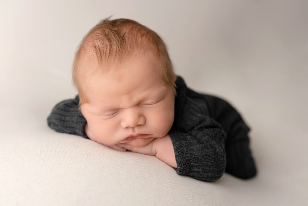 funny photo baby face closed eyes chin on hands