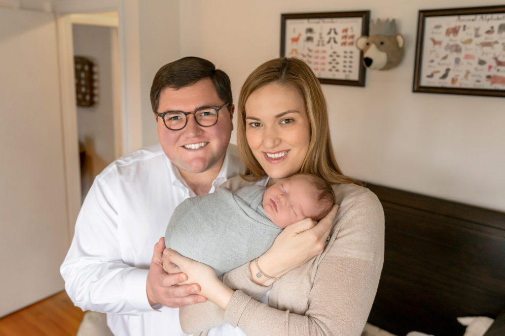 new dad and mom with baby family photograph smiling happy