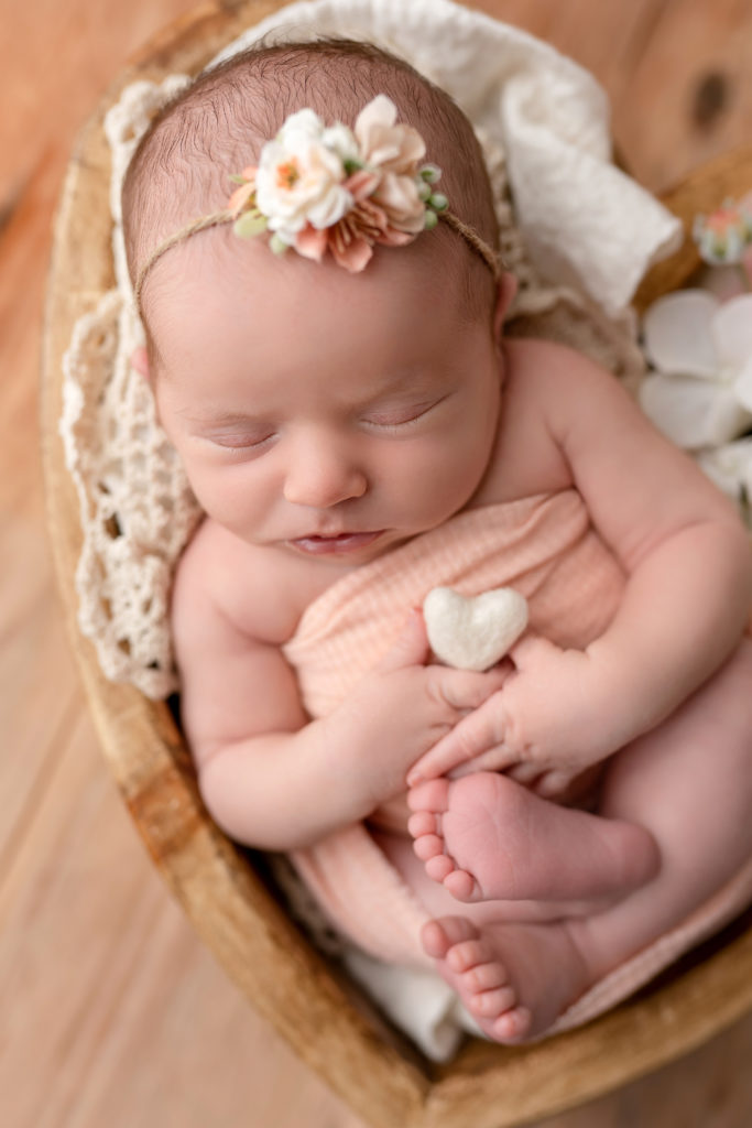cute little baby with foot poking out asleep in heart cradle photo