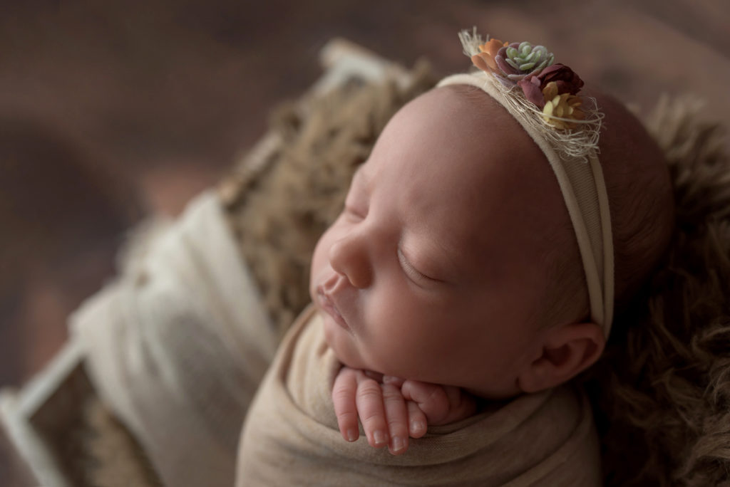 newborn swaddled girl with floral headband