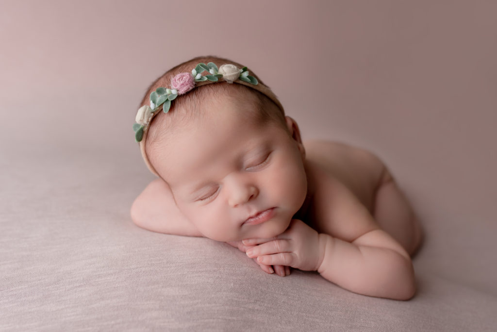 Newborn photoshoot with baby girl wearing a floral headband