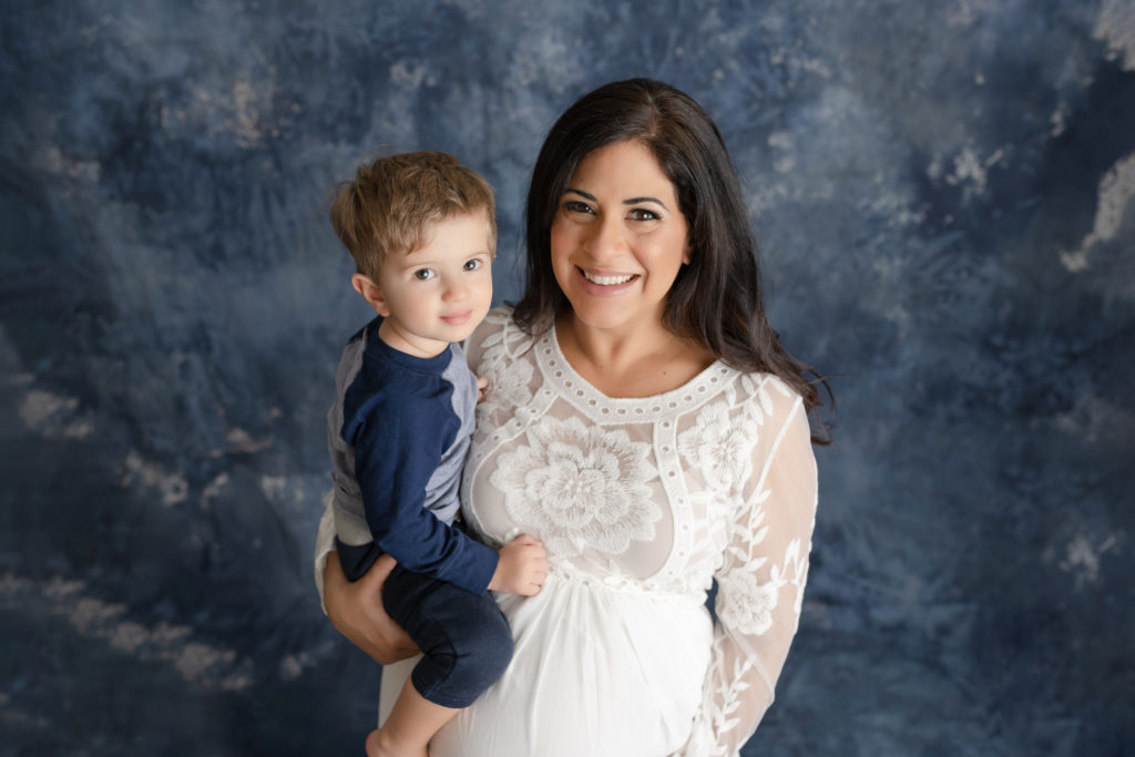 Smiling expecting mom and baby boy photo in studio 
