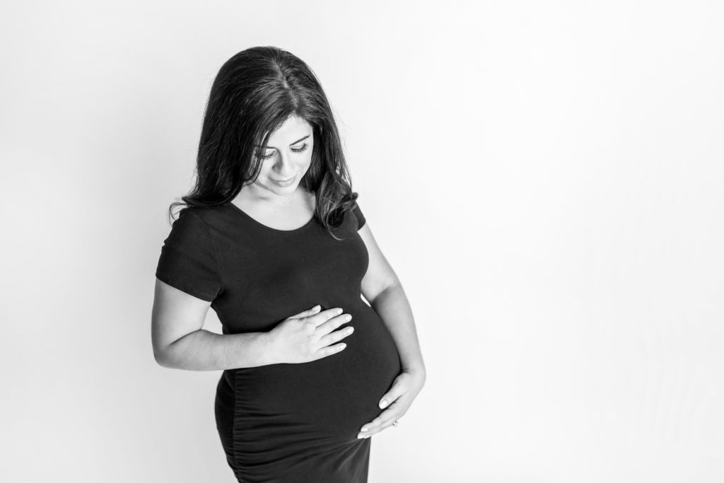 pregnant mom looking down at baby girl in belly maternity photo 
