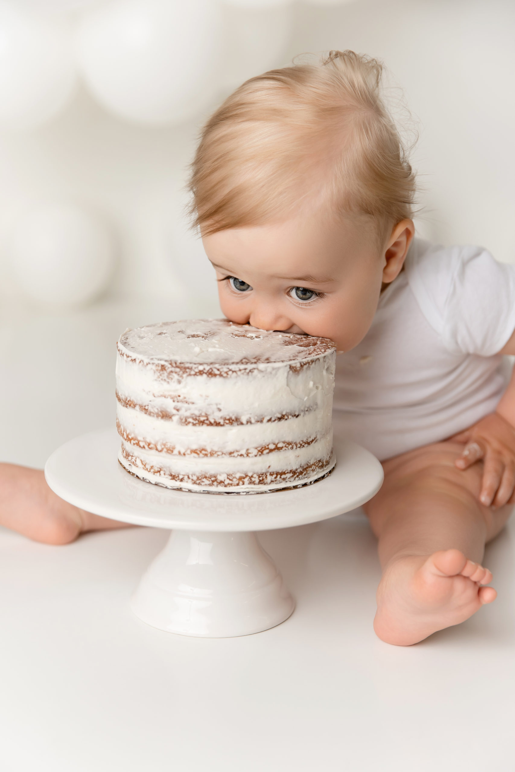 baby boy biting cake smash