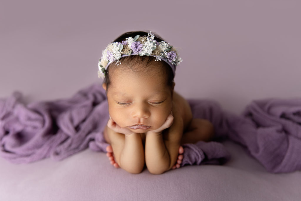 newborn girl in purple frog pose