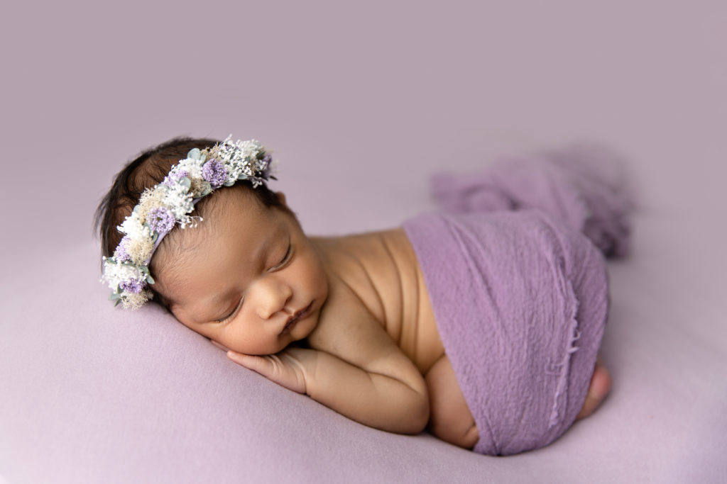 newborn girl in purple sleeping