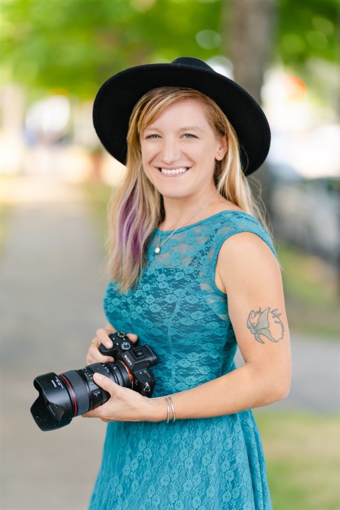 woman wearing hat holding camera
