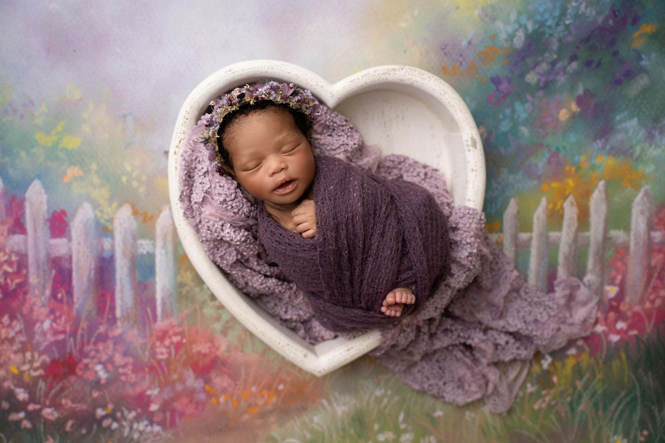 newborn girl in purple shades with rainbow backdrop