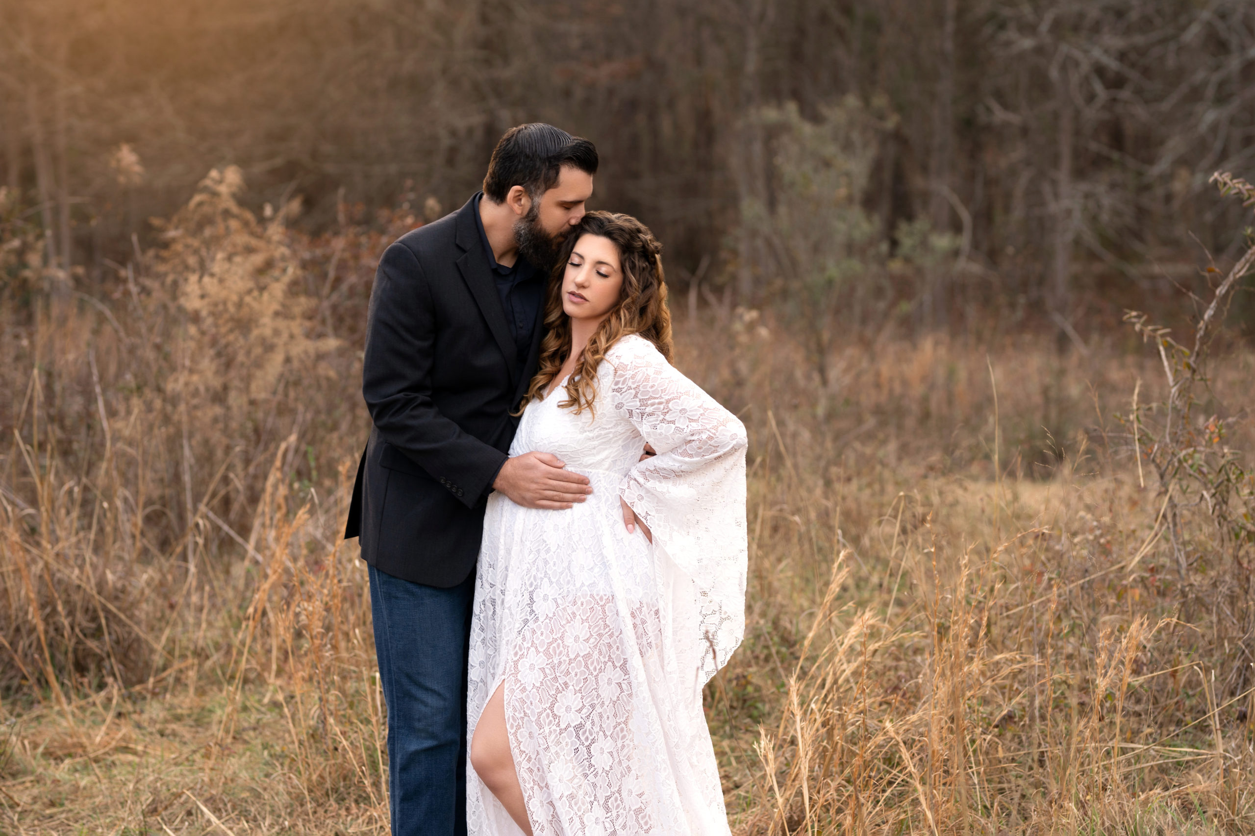 couple pose for maternity session outdoors