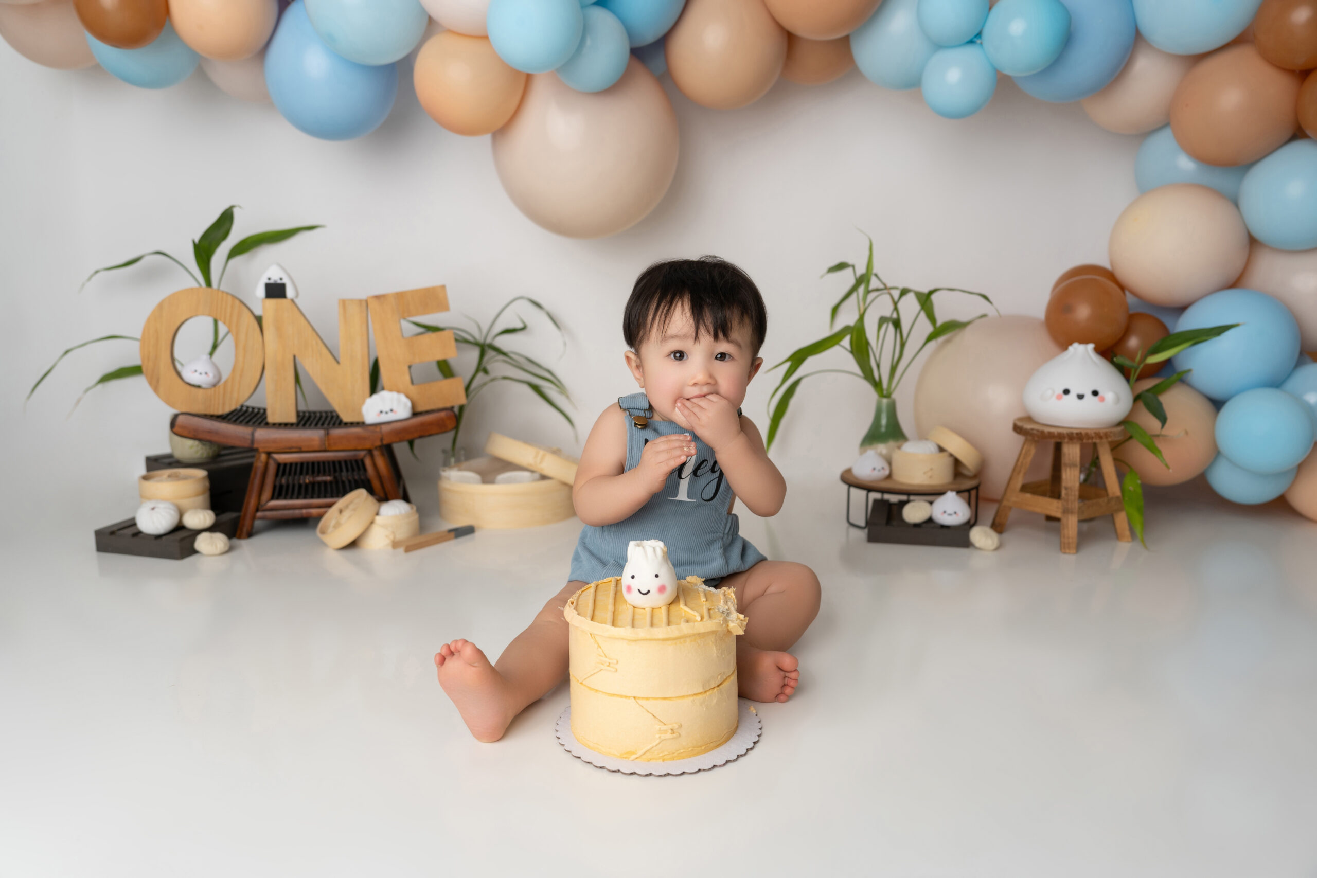 baby boy eats smash cake for dumpling themed session