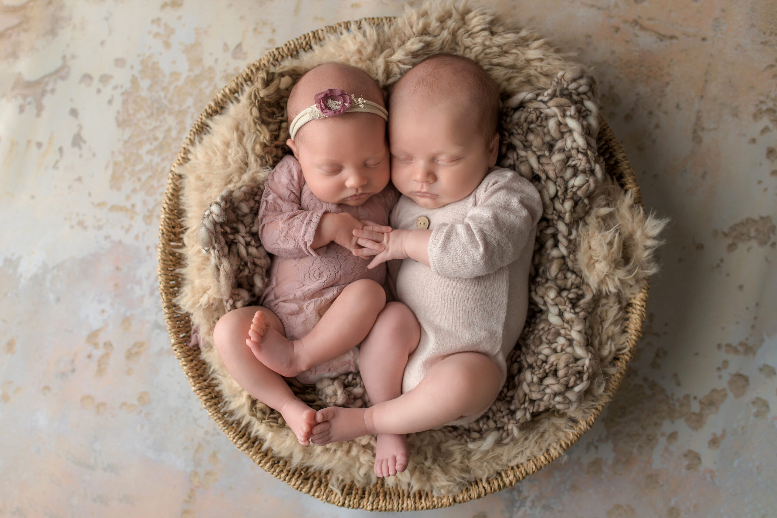 newborn twins snuggle in round bowl prop