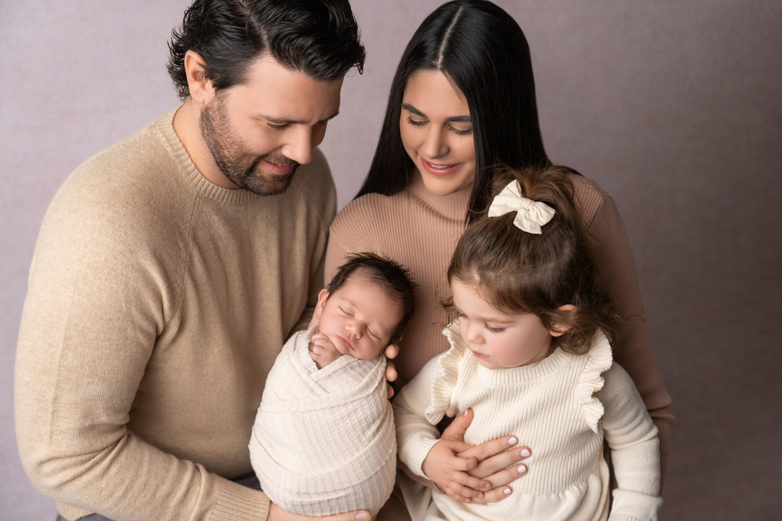 mom and dad holding newborn and big sister for newborn photography session